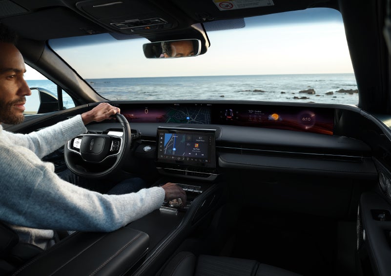A driver of a parked 2025 Lincoln Nautilus® SUV takes a relaxing moment at a seaside overlook while inside his Nautilus. | Apple Lincoln Apple Valley in Apple Valley MN